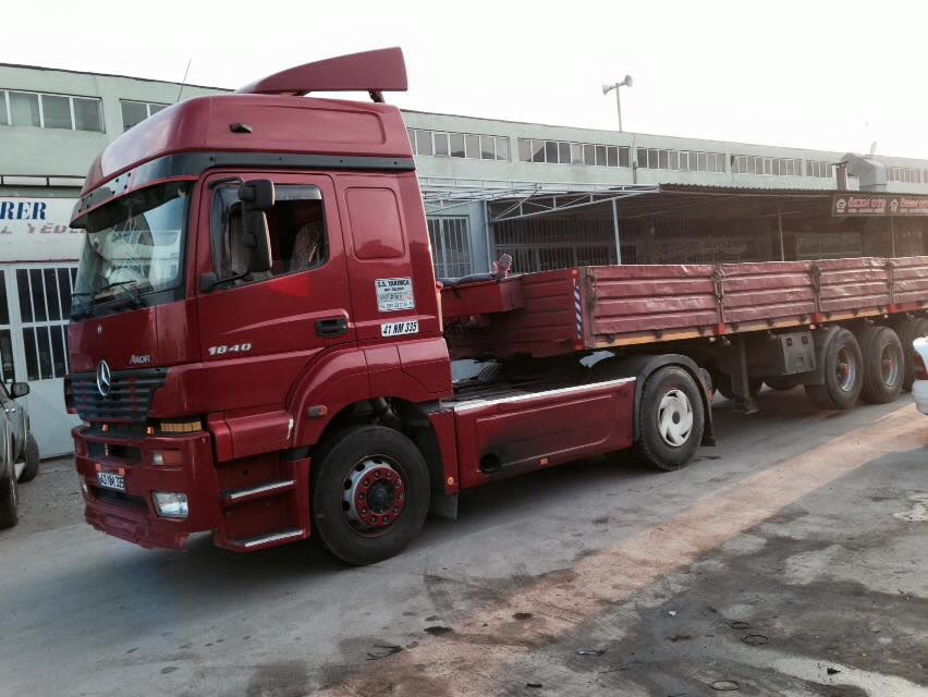 Atölye önünde dorseli kırmızı çekici